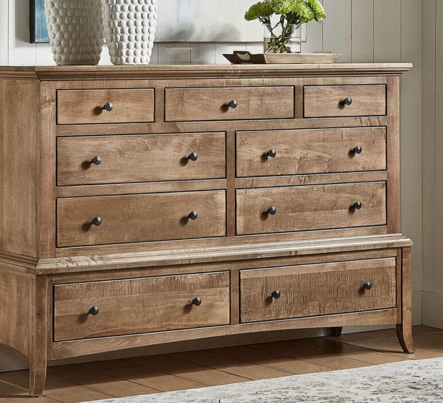 Traditional nine-drawer light brown wood dresser with dark metal knobs.